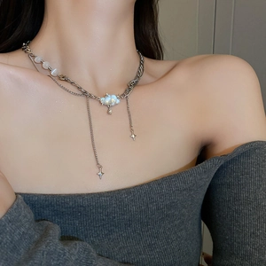 Detail of layered silver necklace with cat-eye stones, cloud pendant and star charms