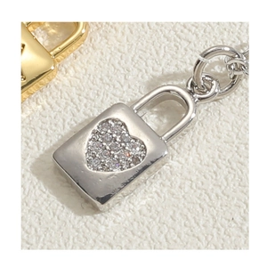 Macro detail of heart padlock pendant featuring pave-set cubic zirconia in gold and silver