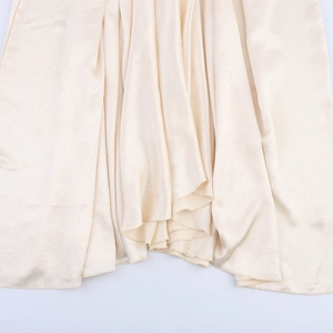 Elegante abito lungo in raso beige con finitura lucida e orlo fluido drappeggiato