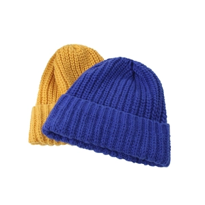 Detailed close-up of blue and yellow chunky ribbed knit beanies for winter warmth