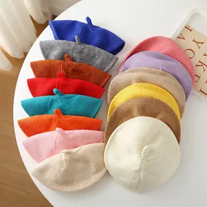 Colorful knitted beret hats for children in various candy colors shown from top view