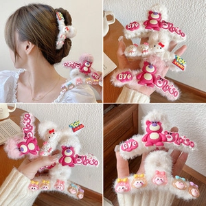 Detail view of white plush hair claw clip with pink strawberry bear and cartoon characters