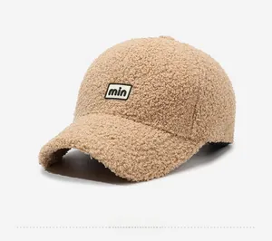 Detail of camel teddy fleece baseball cap with min letter embroidery and soft texture