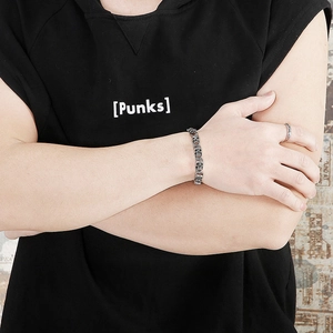 Detail of silver skull link bracelet with vintage punk style worn by male model