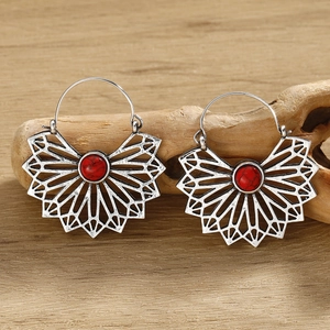 Detailed view of silver bohemian earrings with geometric patterns and red stone inlay