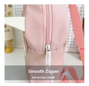 Close-up of smooth white zipper and durable nylon fabric on pink cat paw backpack