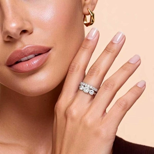 Close-up of a 3-stone zircon ring set in silver finish on a female model finger