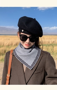 Detail of grey knitted scarf with Greek key pattern and chic black wool beret hat