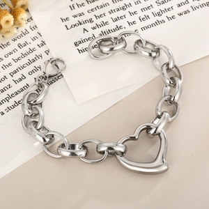 Silver chunky chain bracelet with a large heart pendant on vintage script background