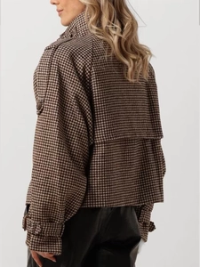 Detailed side view of houndstooth plaid wool jacket with buttoned cuffs and epaulettes