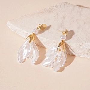 Vue détaillée des boucles d'oreilles à pompon pétale blanc et perle sur pierre