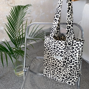 Detail of vintage leopard print canvas tote bag hanging on a chair in a lifestyle setting