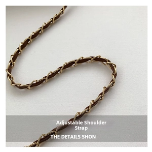 Detail of adjustable brown leather and gold metal chain strap for women's crossbody bag