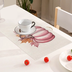 Macro detail of pumpkin and maple leaf print on autumn placemat with dining setup