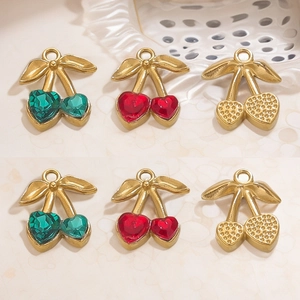 Présentation de pendentifs cerise avec gemmes cœur rouges et vertes finition dorée