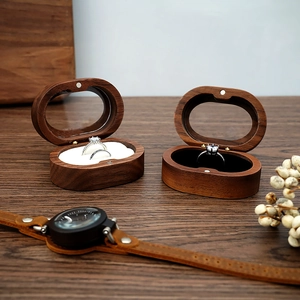 Detailed view of an oval black walnut ring box with soft velvet lining and wood texture