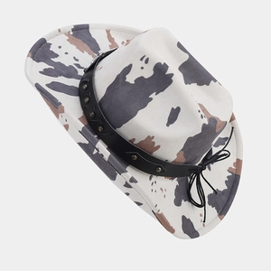 Detail of cow print western cowboy hat with studded black leather band and rivet trim