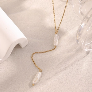 Baroque pearl tassel necklace in 18K gold plated stainless steel on beige background