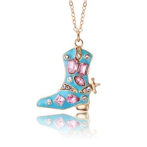 Dettaglio di un ciondolo a stivale dorato con smalto blu e cristalli rosa scintillanti