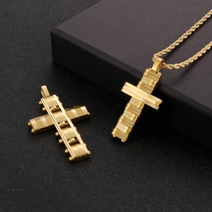 Detailed view of architectural gold stainless steel cross pendant on black gift box