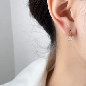Elegant gold drop earrings with pear cut cubic zirconia stones shown on model