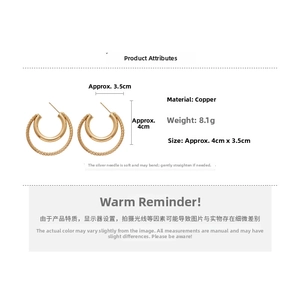 Detailed view of golden double-layer C-shaped earrings with textured and smooth rings