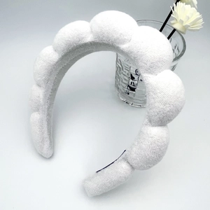 Macro detail of the plush terry cloth texture on a white padded spa headband