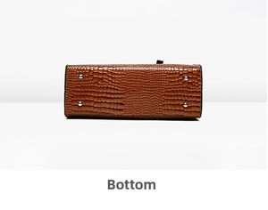 Detailed bottom view of brown faux crocodile leather bag with four silver metal studs