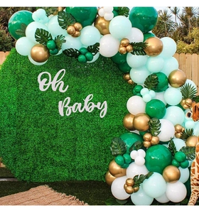 Détail d'une arche de ballons vert et blanc avec plaque Oh Baby et décor de palmier