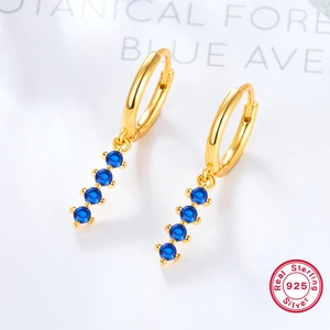 Detailed macro view of 925 sterling silver gold earrings with four blue gemstones