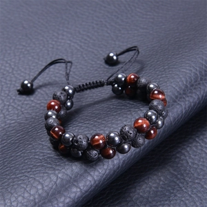 Detail of double-layer woven bracelet with blue tiger eye and lava stones on black leather