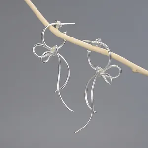 Elegant handmade S925 sterling silver bow ribbon drop earrings hanging on a branch