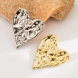Irregular wrinkled heart brooch in gold and silver finish with lava texture on rock