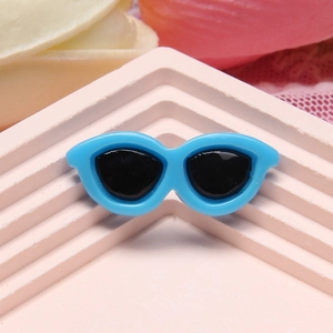 Macro view of a 2.9cm blue resin cat-eye sunglasses miniature on a pink display stand