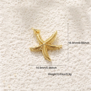 Macro view of gold starfish pendant with texture details on sand, 16.9mm x 14.9mm size