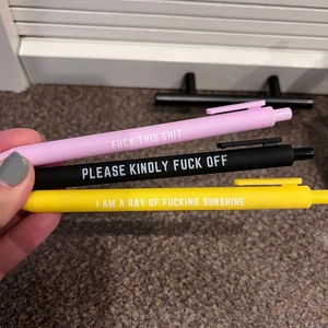 Funny pens with sarcastic quotes held in hand showing matte finish and bold lettering