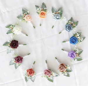 Flat lay of 12 multi-color artificial rose boutonnières with elegant lace stem wrap