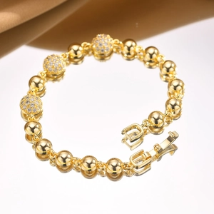Macro detail of gold bead bracelet with sparkling zircon stones and a secure folding clasp