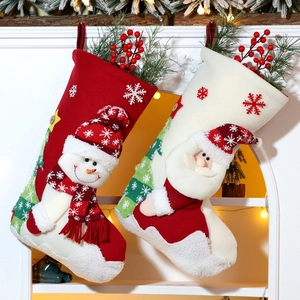 Close-up of knit Christmas stockings with snowman and Santa patterns on a white fireplace