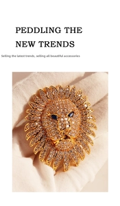 Detailed close-up of a golden lion head brooch encrusted with white and blue zircons