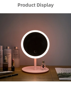 Close-up of pink LED makeup mirror with ring light on a wooden vanity with cosmetics