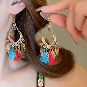 Detail view of Bohemian tassel drop earrings featuring leaf charms and colorful beads