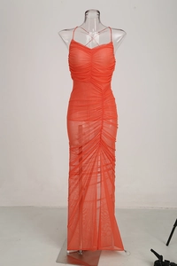 Detail of elegant orange mesh ruched dress showing layered texture and side slit