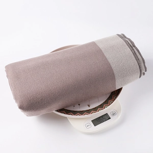Weight check showing a coffee-colored striped poncho wrap weighing 465.7 grams on a scale