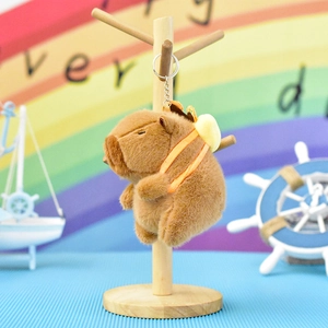 Detailed shot of a cute brown plush capybara keychain on a wooden stand