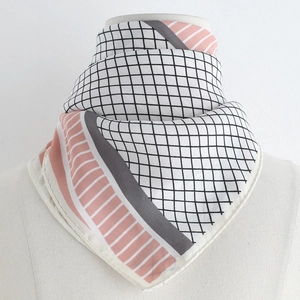 Detail of geometric pattern silk scarf styled as an elegant necktie on a mannequin