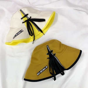Détail d'un chapeau bob pliable avec rubans à nœuds et broderies de lettres stylisées