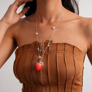 Detail of red strawberry pendant with white pearls and silver star on a metal necklace