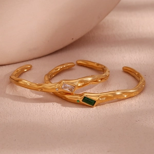 Detail of 18K gold plated lava texture open bangles with white and green zircons