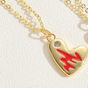 Macro shot of gold heart pendant with red pulse line pattern and sparkling zircon detail